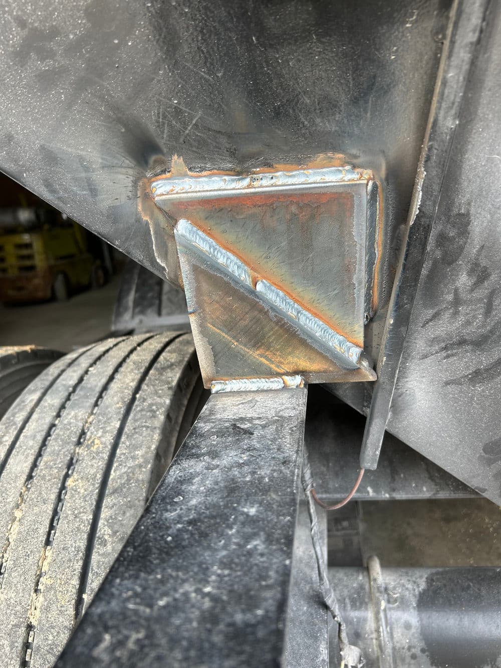 Close-up of a welded metal bracket on heavy machinery, showcasing detailed craftsmanship.