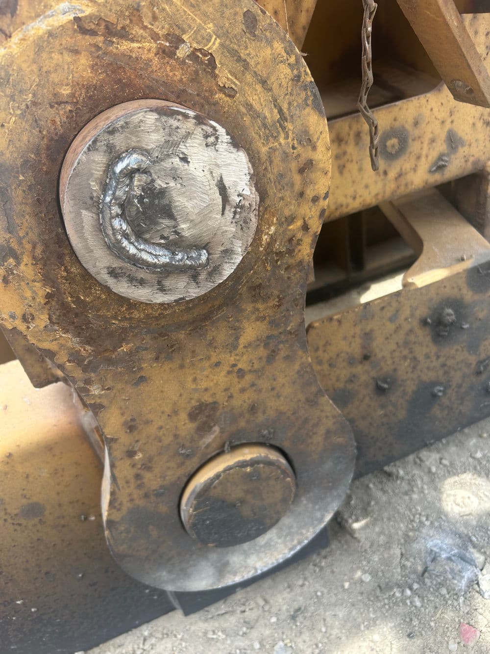 Welded metal joint on heavy machinery, showcasing industrial equipment wear and maintenance.