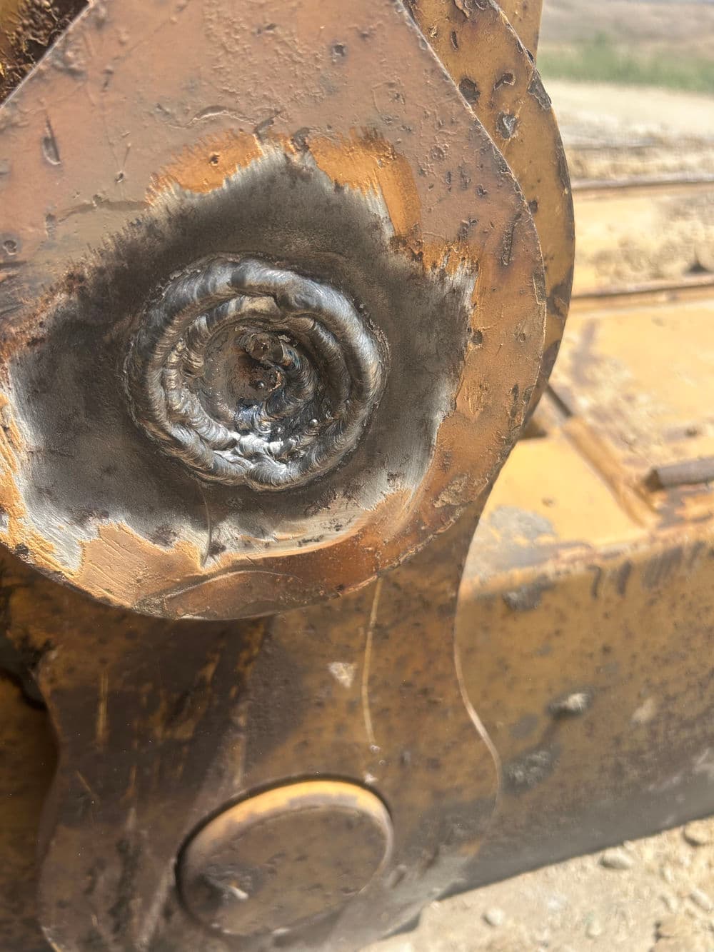 Welded steel joint on heavy machinery, showing detailed metalwork and texture.