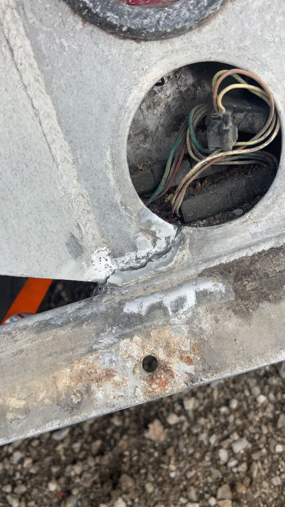Close-up of damaged metal with wires visible in a vehicle's bodywork.