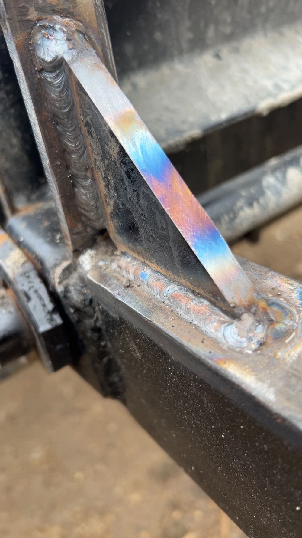 Close-up of a vibrant weld joint on metal beams showcasing precise craftsmanship.