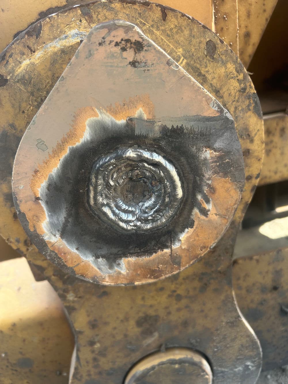 Close-up of a welded metal joint showing intricate patterns and textures.